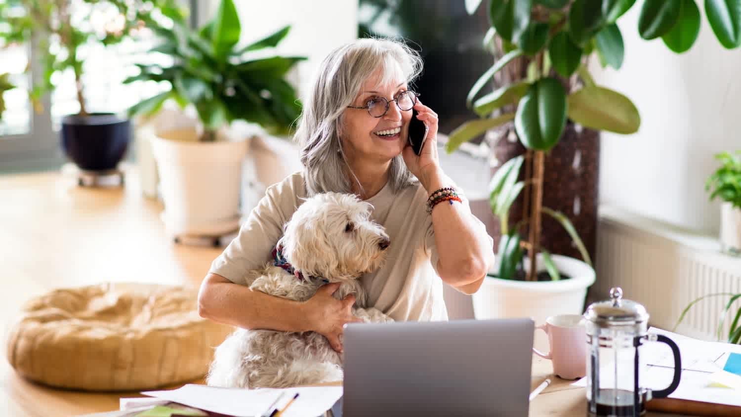A woman with her dog at the table in home office