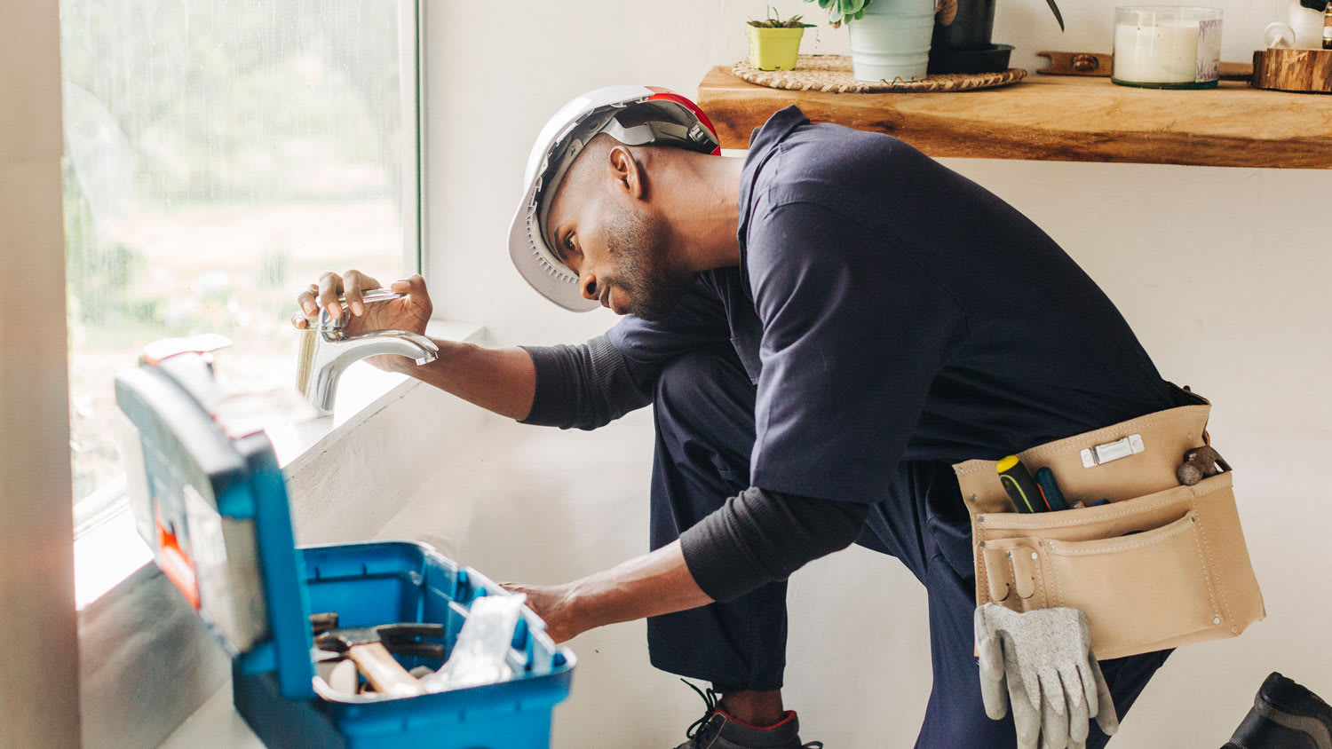A plumber inspecting a faucet