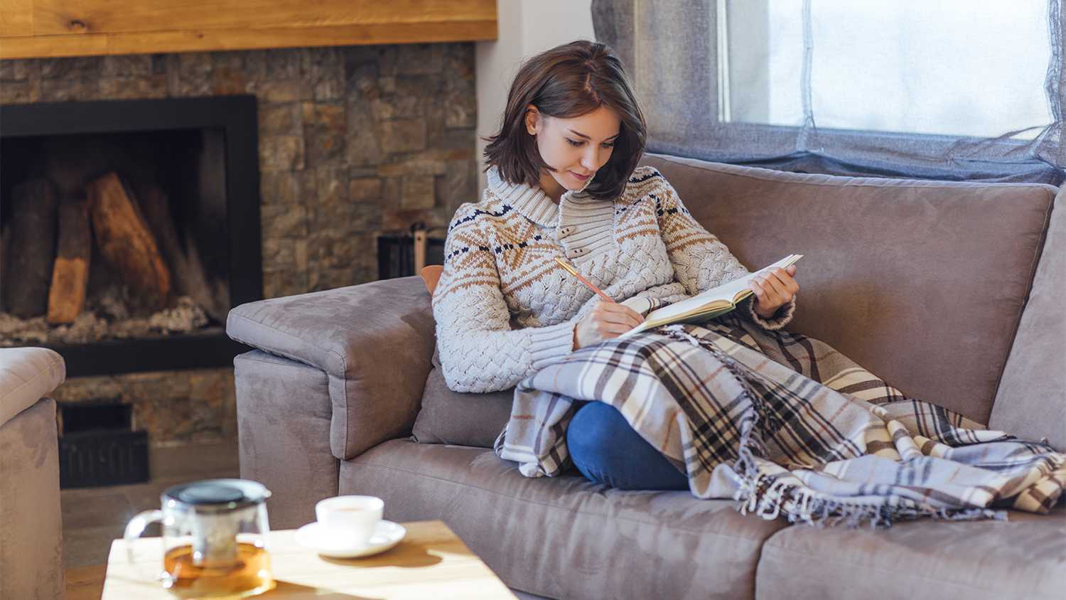 woman laying on couch under a blanket