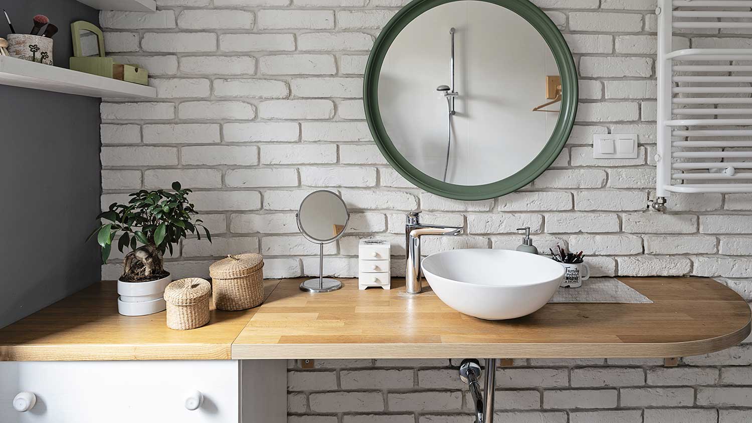 bathroom with brick wall and round mirror