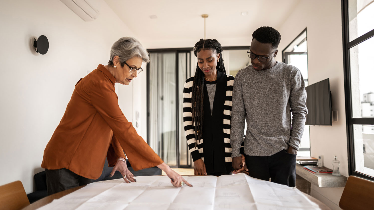 A contractor talking to homeowners about blueprints