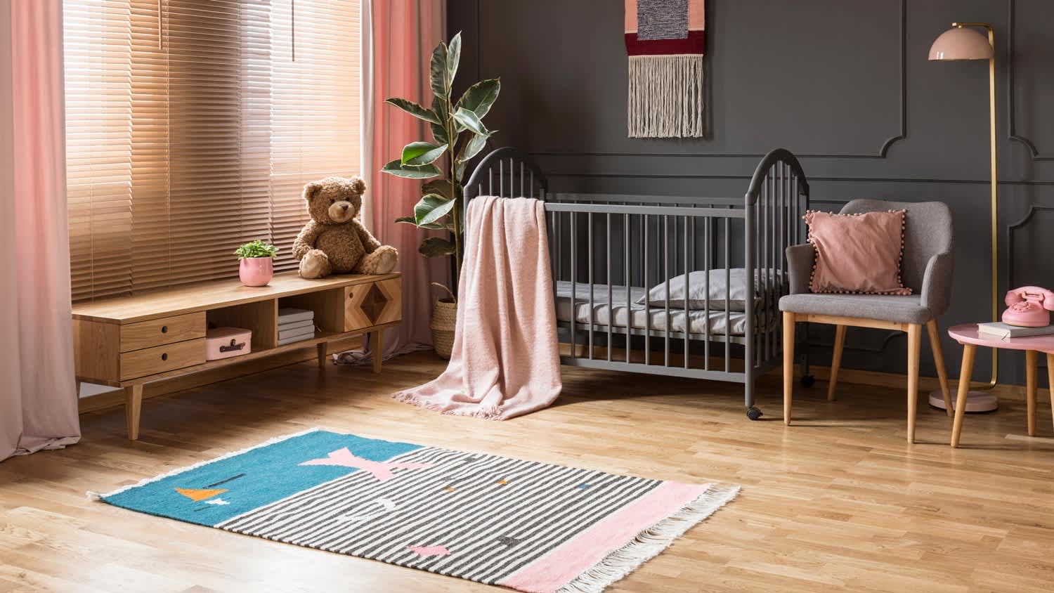 A child’s room with a baby crib with hardwood floors and a rug