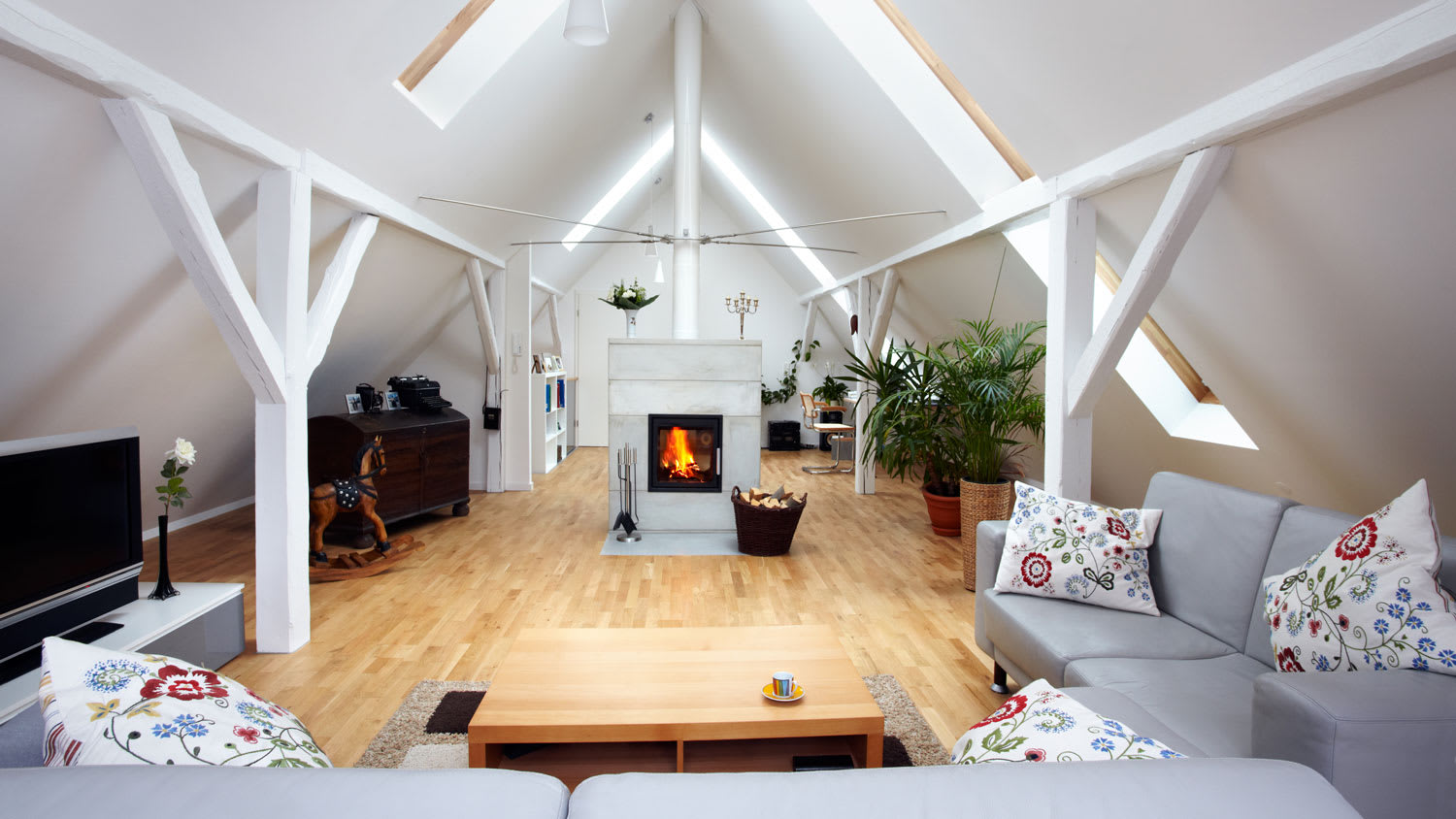 A living room with a fireplace in an attic