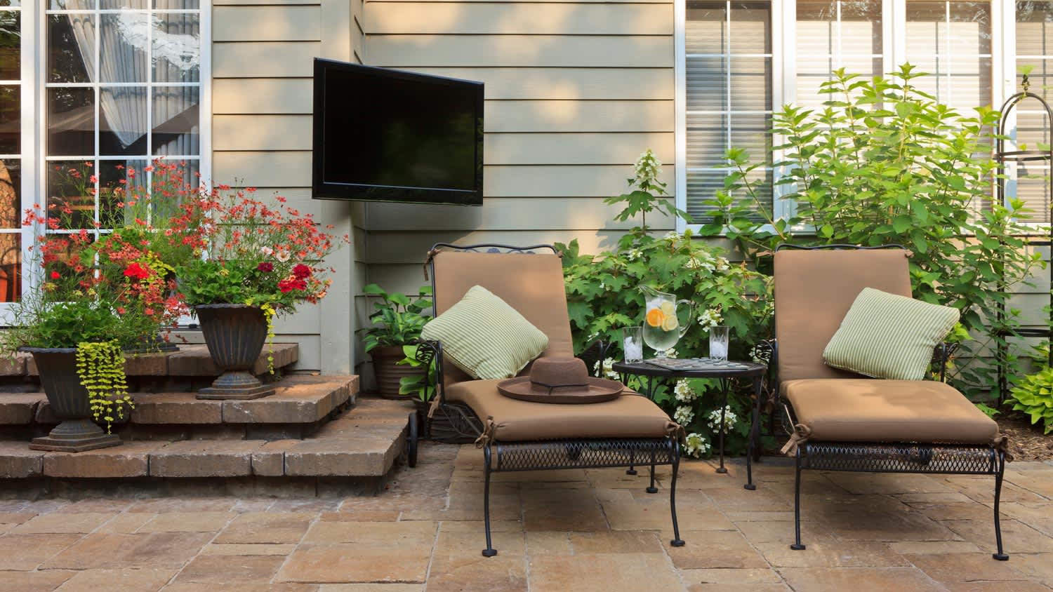 A patio with two lounge chairs and a tv