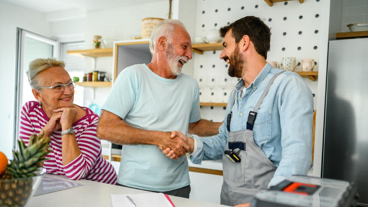 A plumber giving a repair estimate to a senior couple