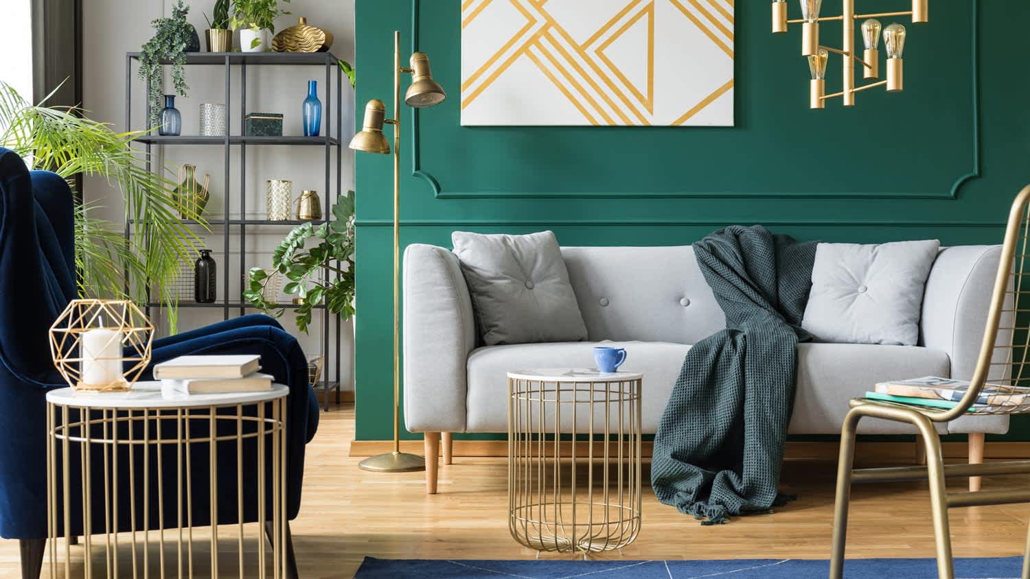 A living room with emerald wall and gold accents