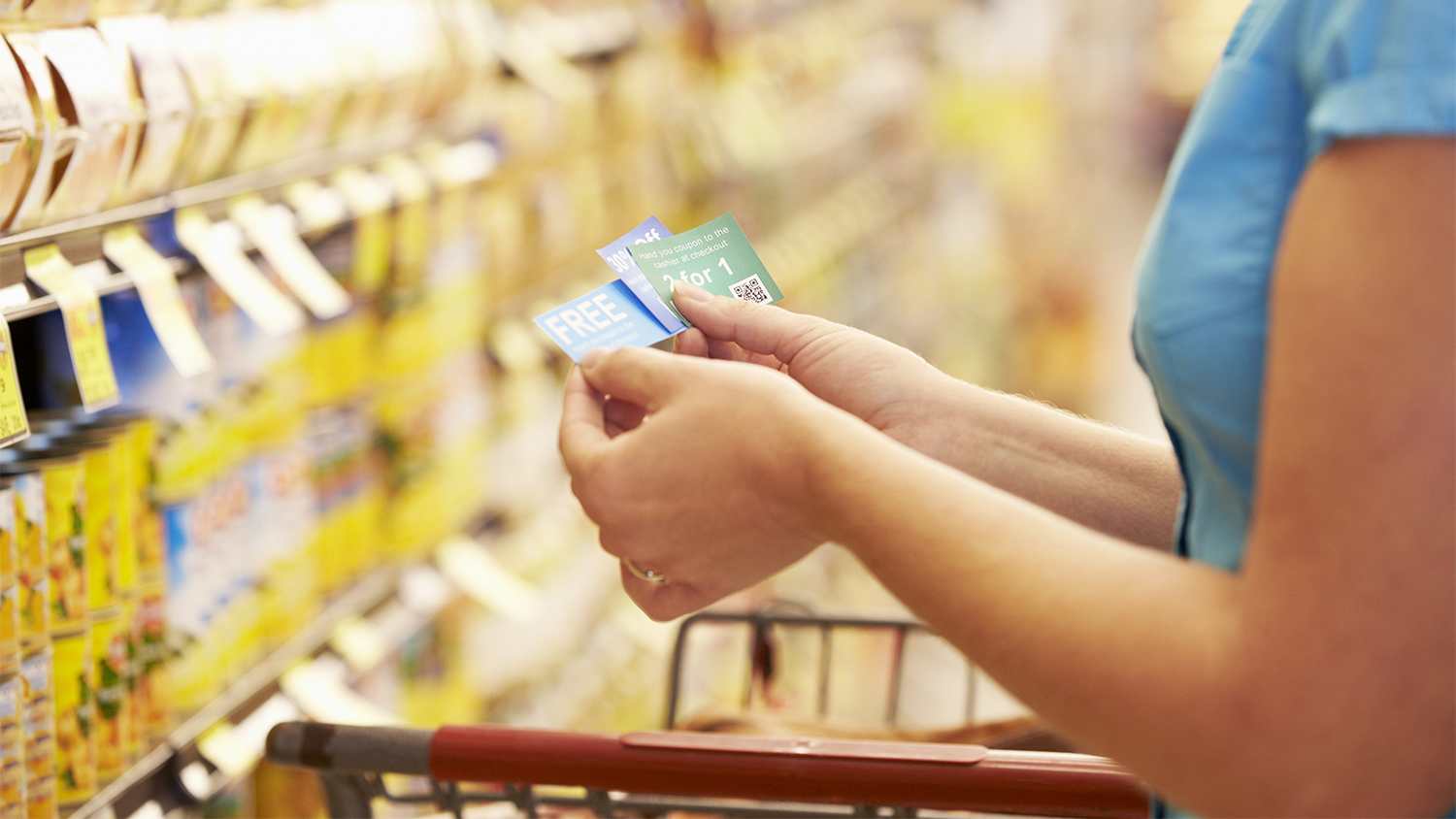 woman looking at coupons in supermarket
