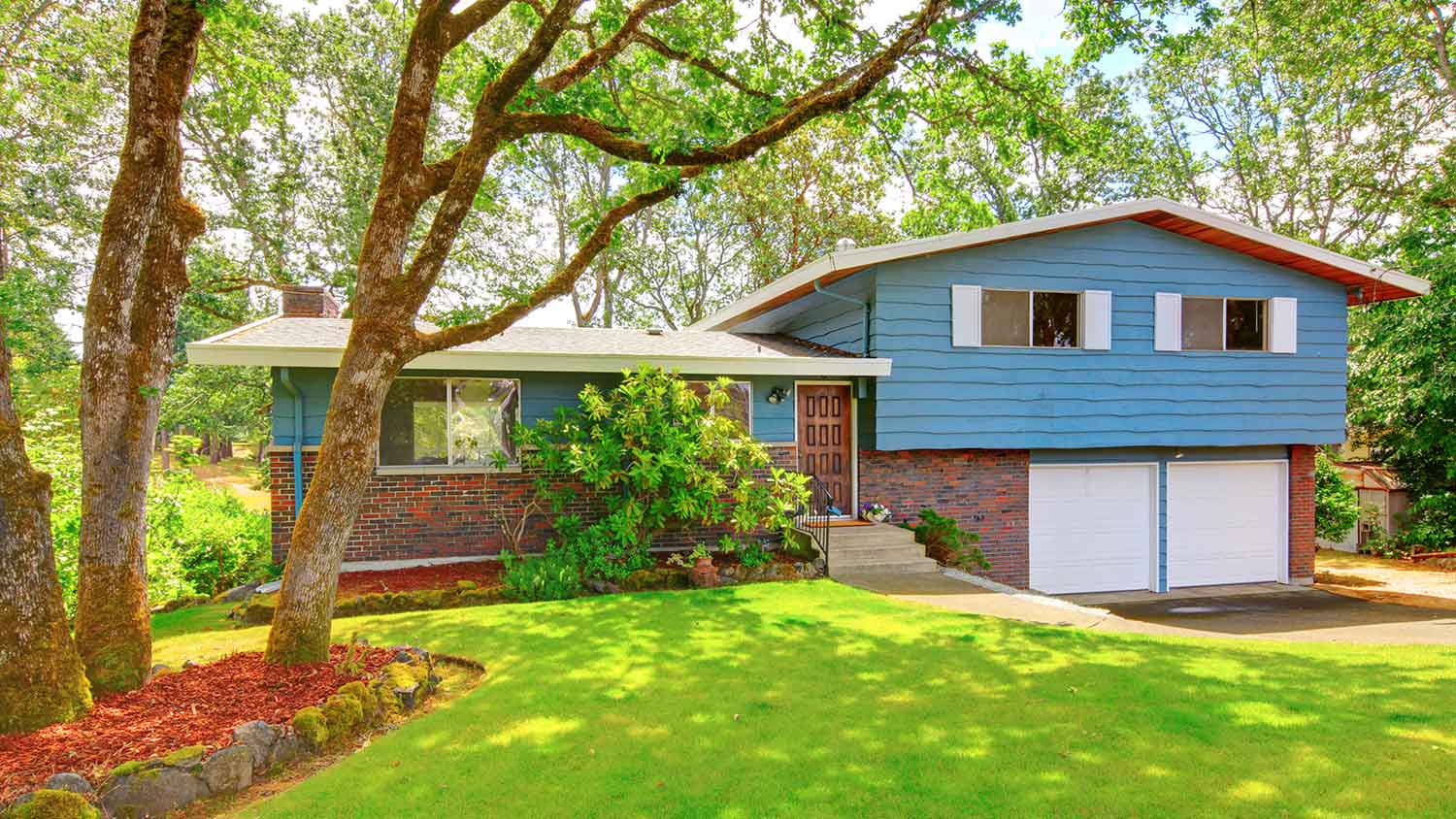 Blue rambler house with two car garage