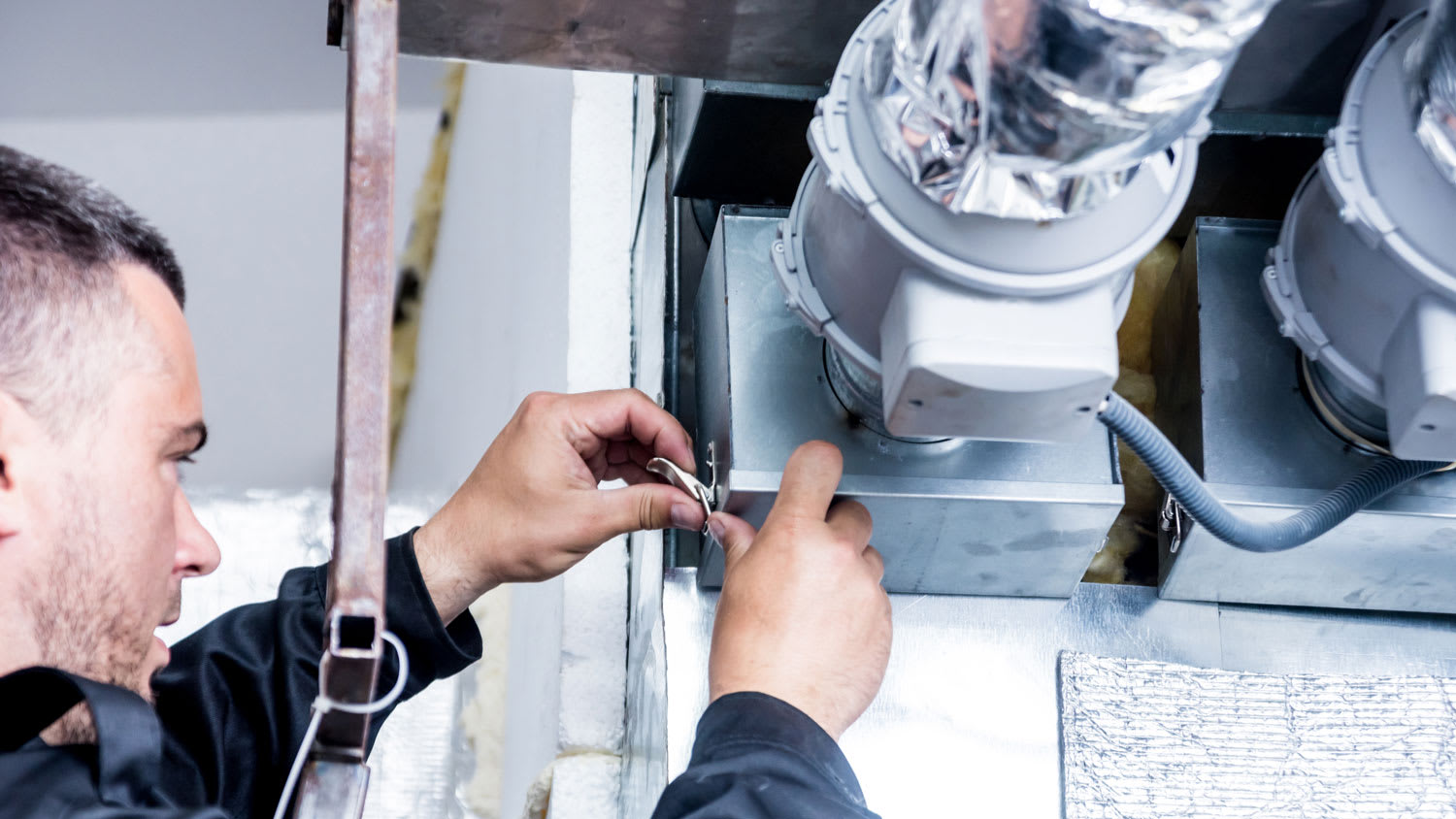 A contractor examining a house’s ducts