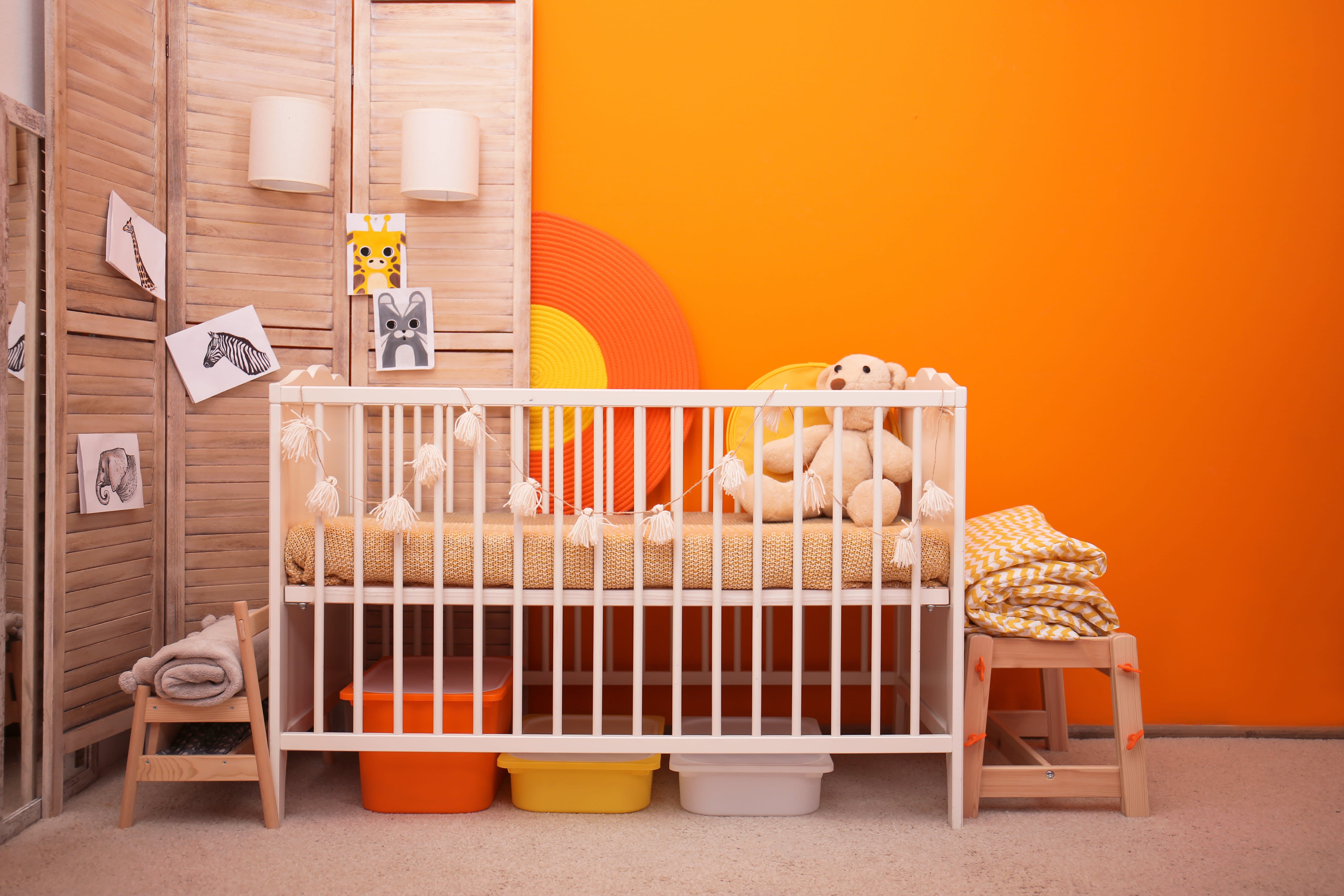 Baby nursery with bright orange wallpaper