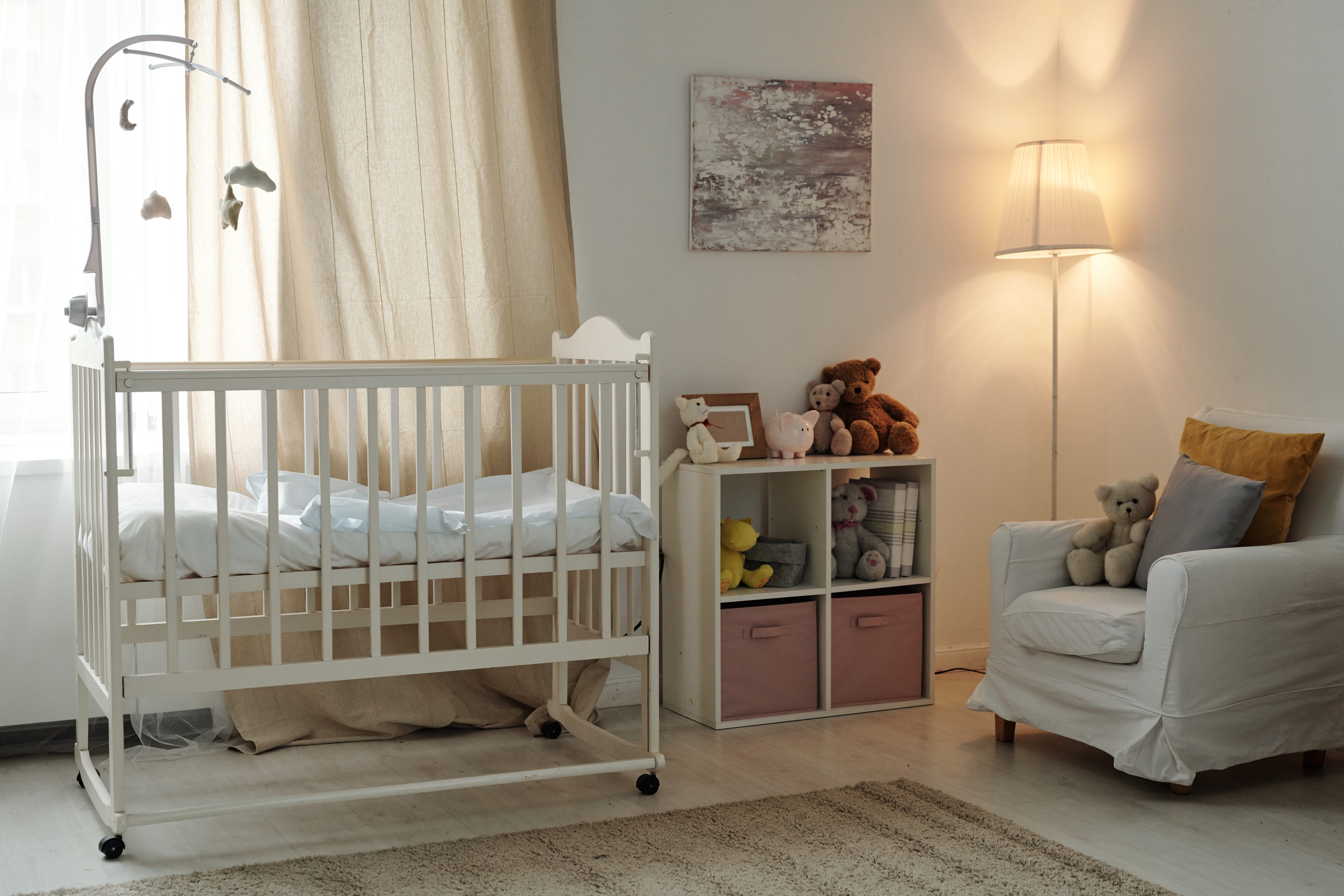 Cozy white nursery with lamp in the corner