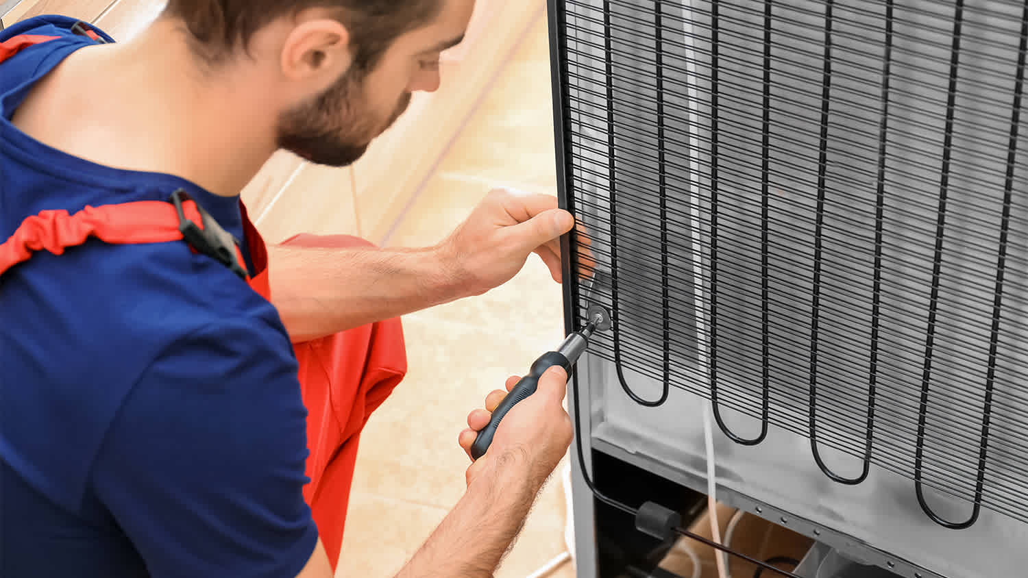 technician working on back of fridge
