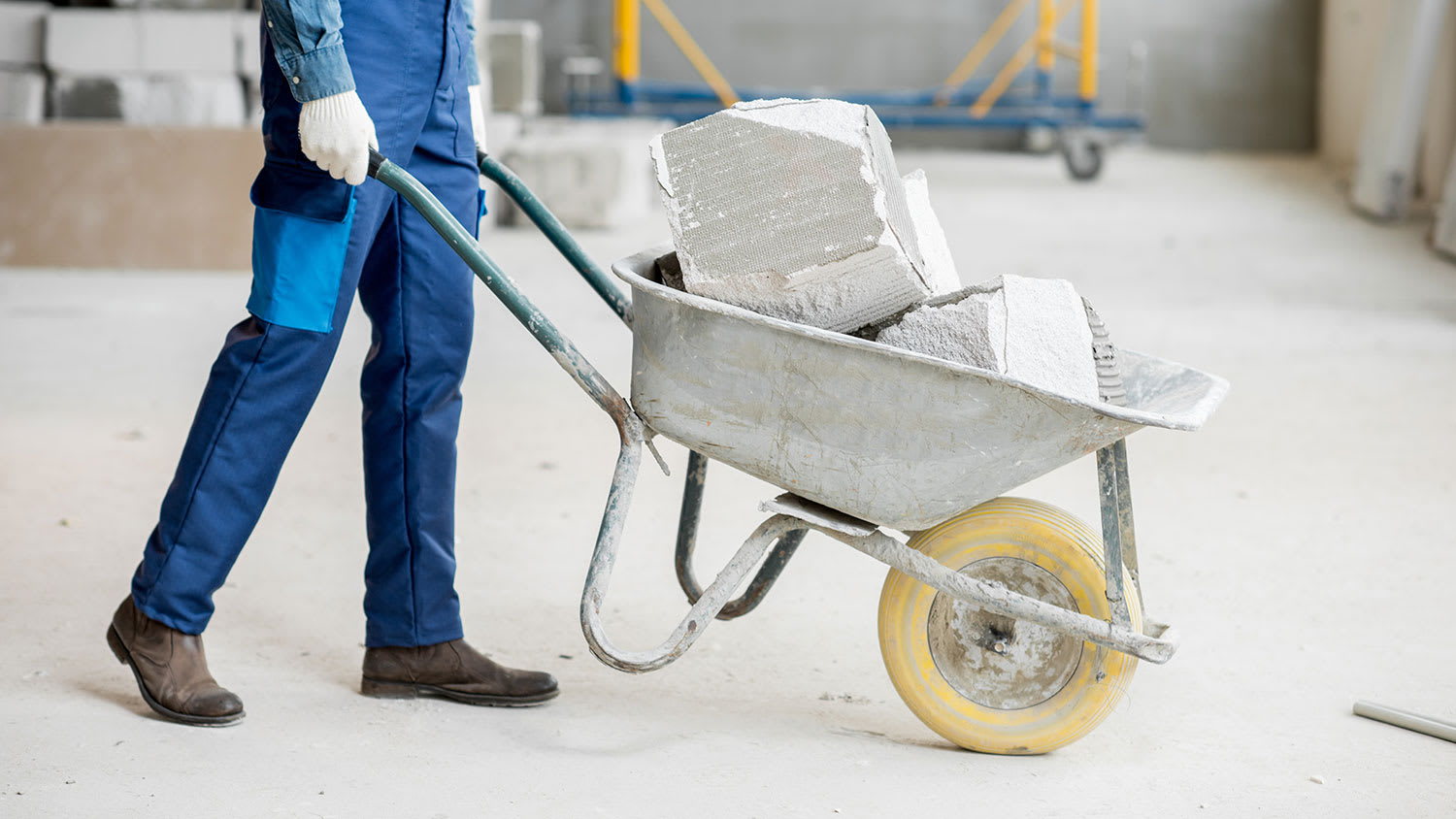 Worker carrying concrete blocks with a wheelbarrow