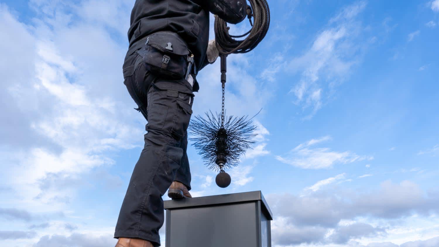 Chimney sweep with stovepipe hat upon the roof