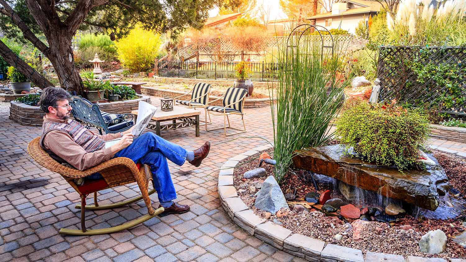Man reading a newspaper on the patio