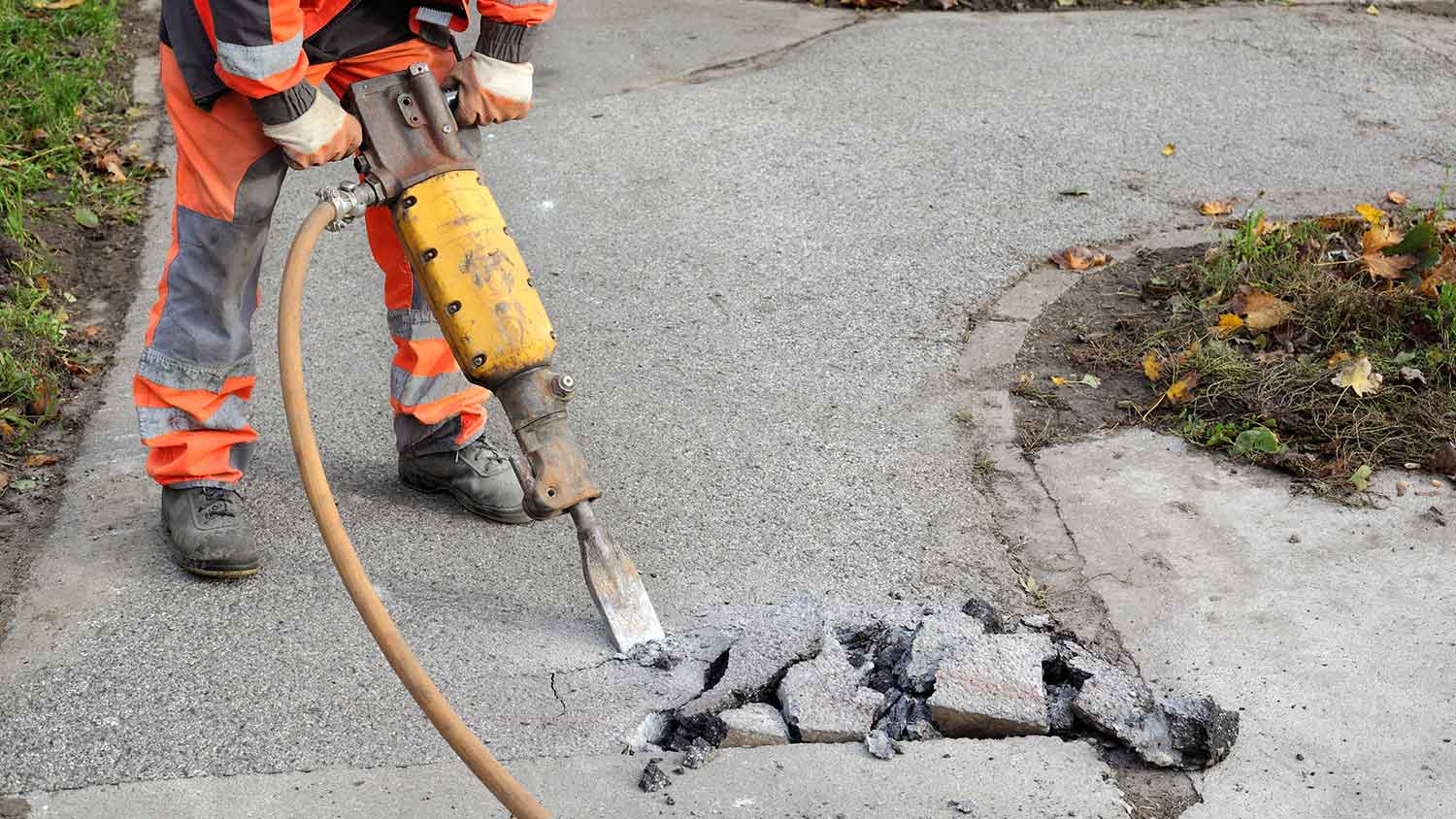 Worker removing concrete with a jackhammer
