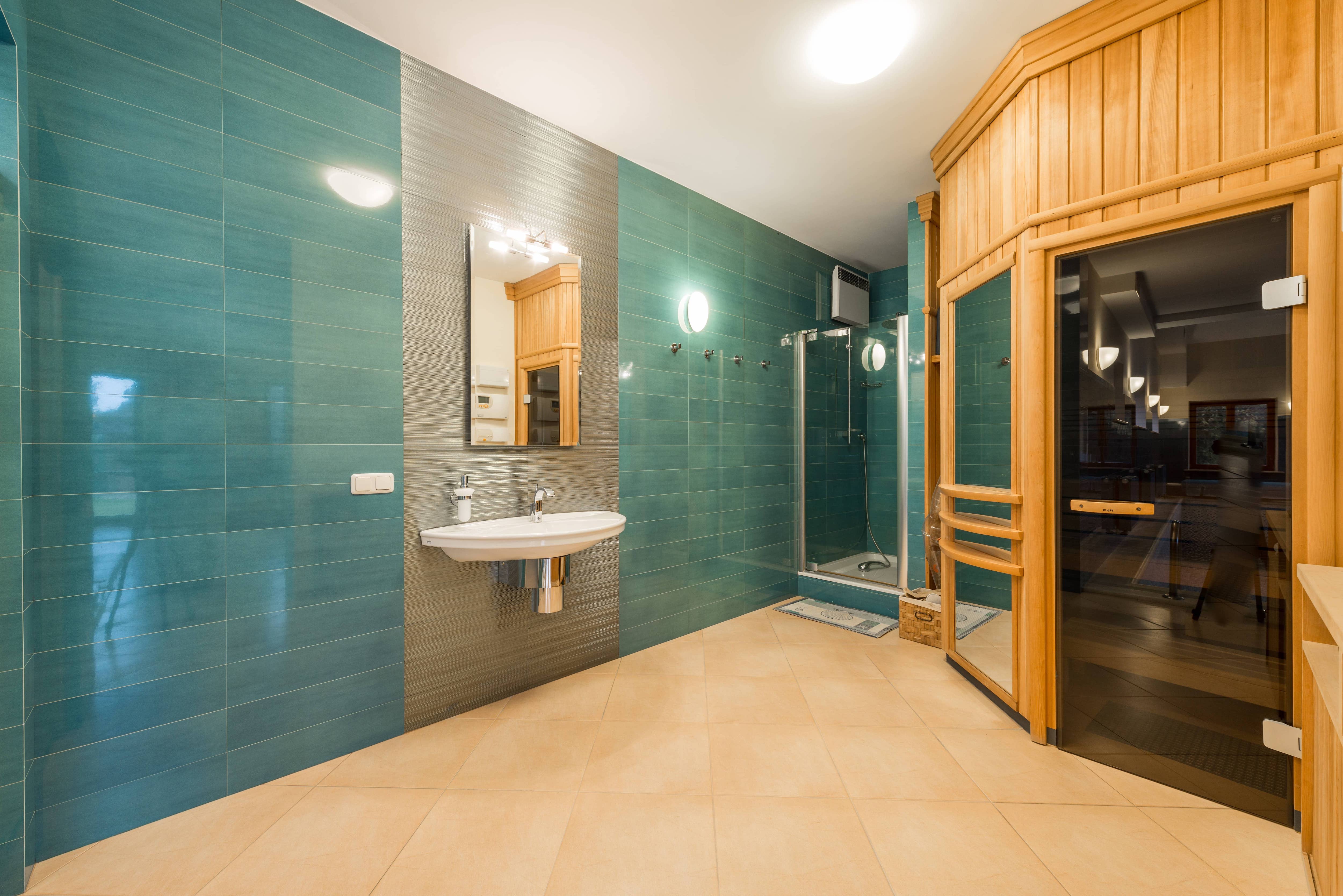 Large bathroom with blue tiles and sauna
