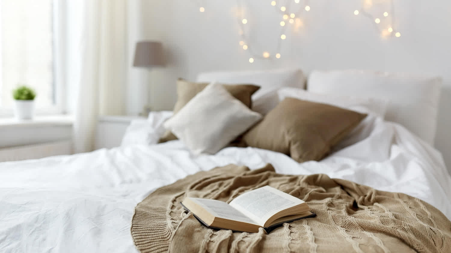 A cozy bedroom with lights hanging from the wall