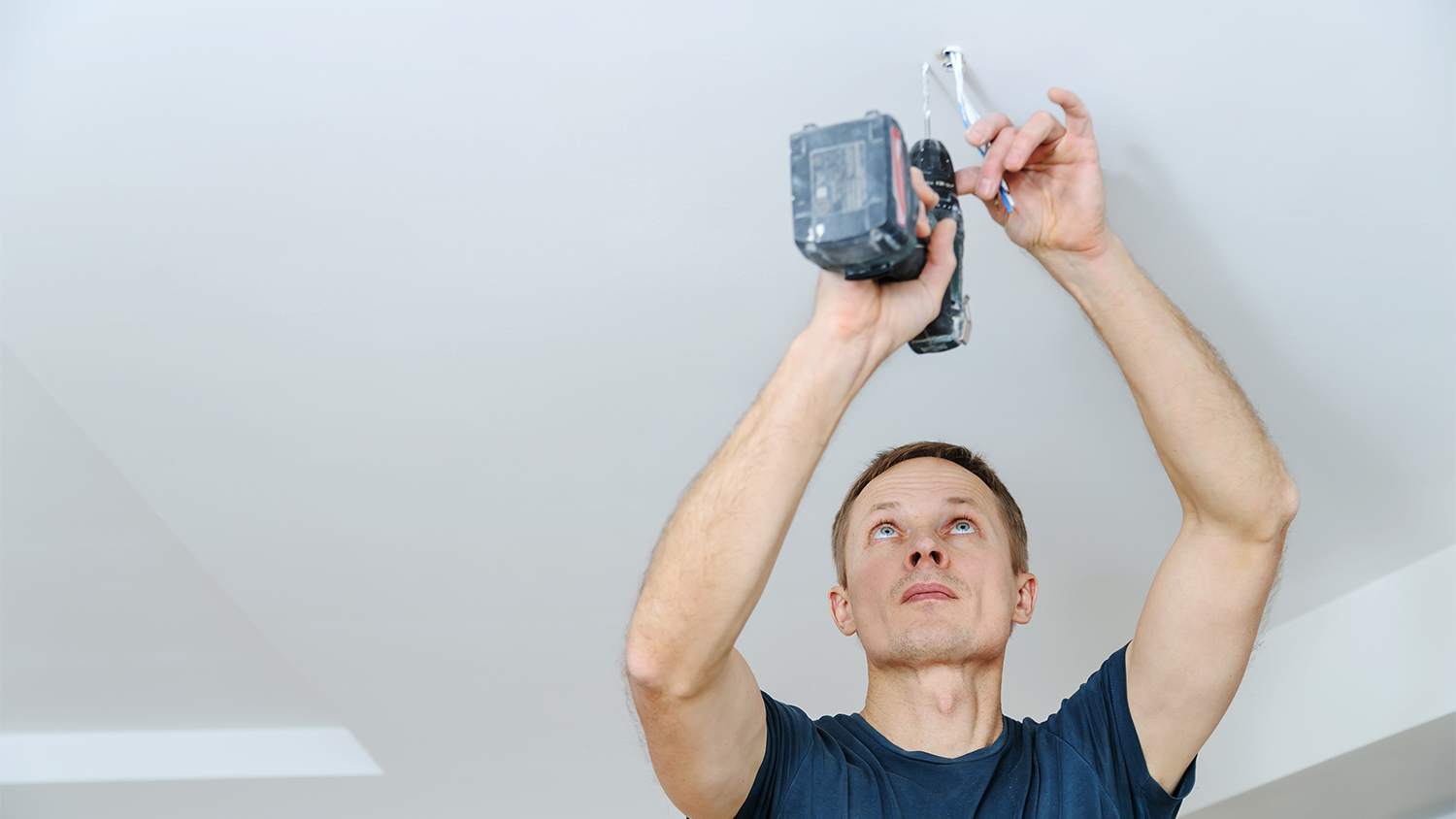 technician installing ceiling lamp fixture