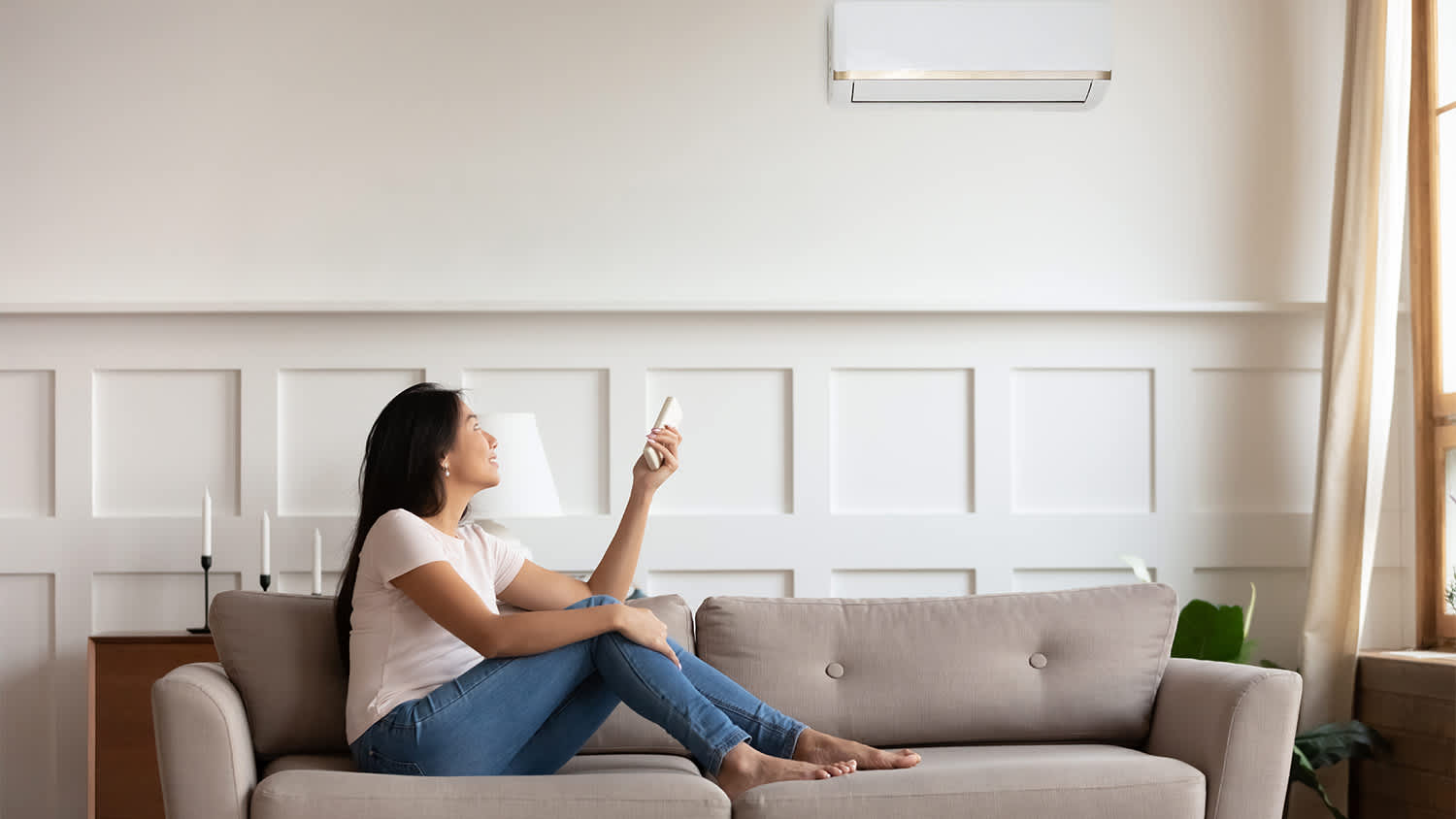 woman on couch turning off ac