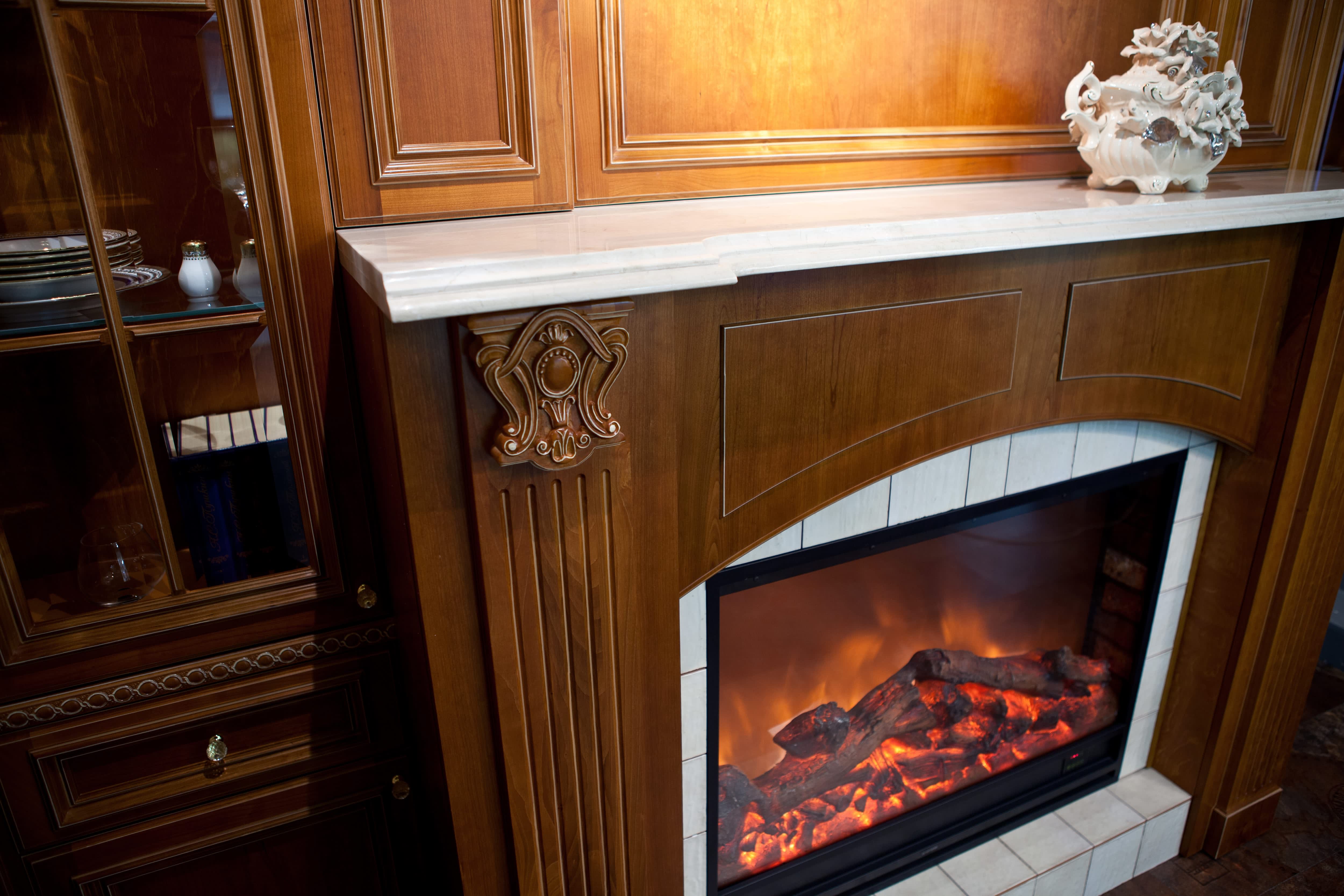 Electric fireplace with white marble mantel and dark wood fireplace surround