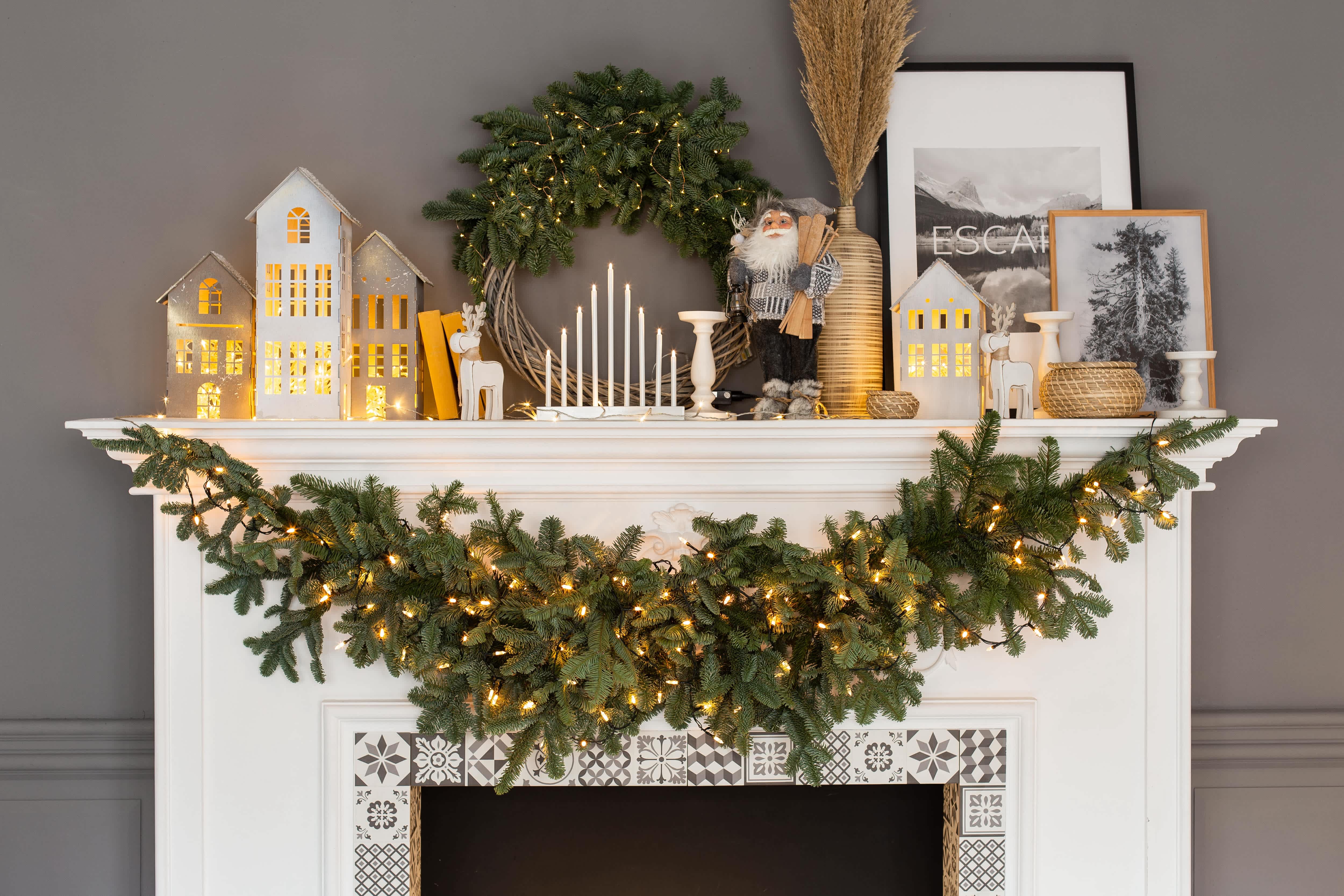 White fireplace mantel decorated with Christmas decor