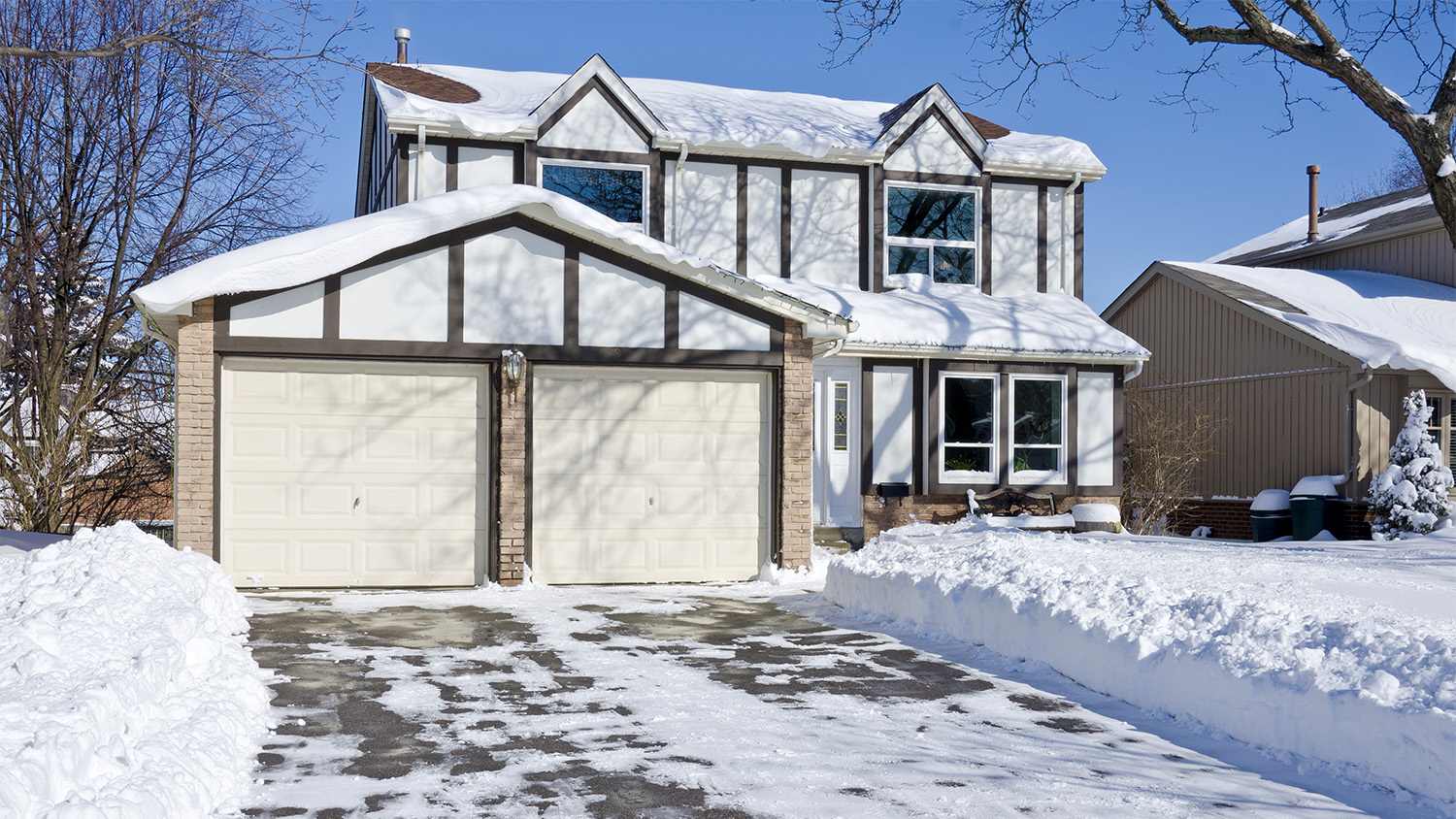 house with snow and ice on driveway