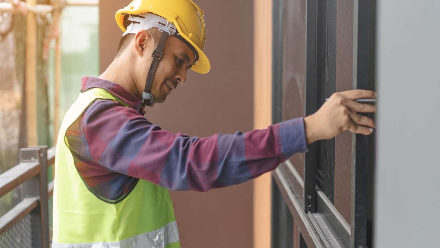 A professional inspecting a house’s sliding windows