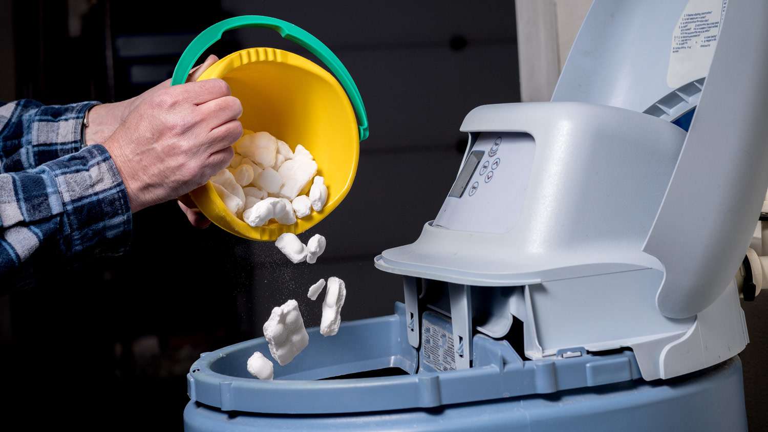 A man adding salt in a water softener