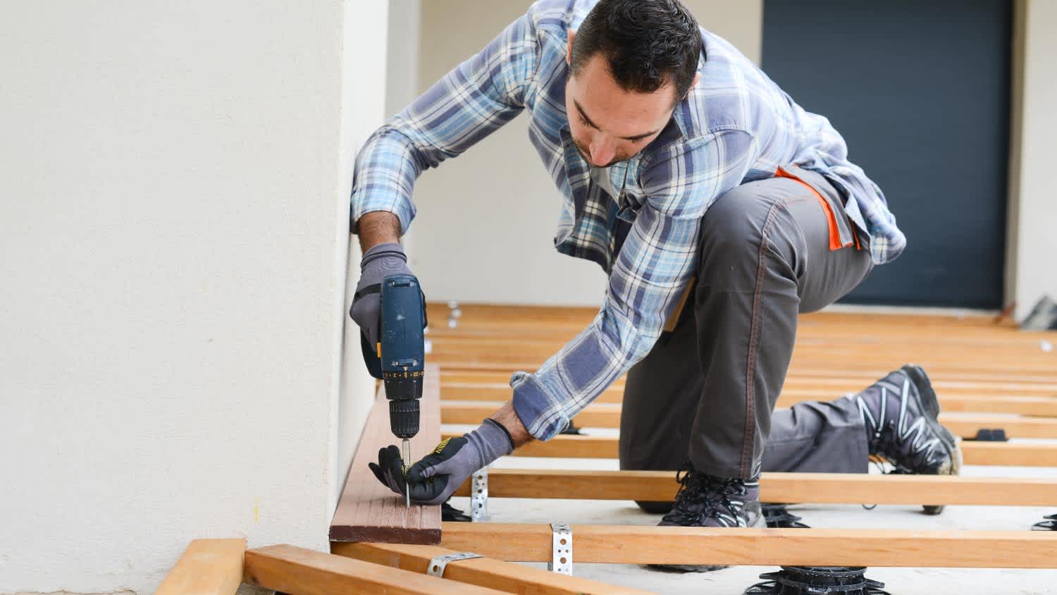 A carpenter installing a new wooden deck