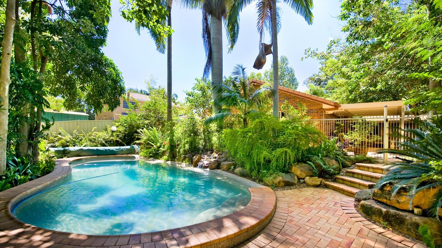 A paver backyard with a swimming pool