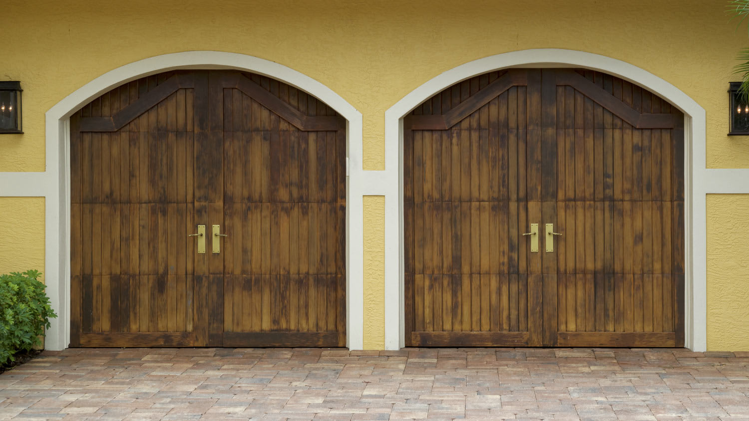 A paver driveway leading to a two-door garage