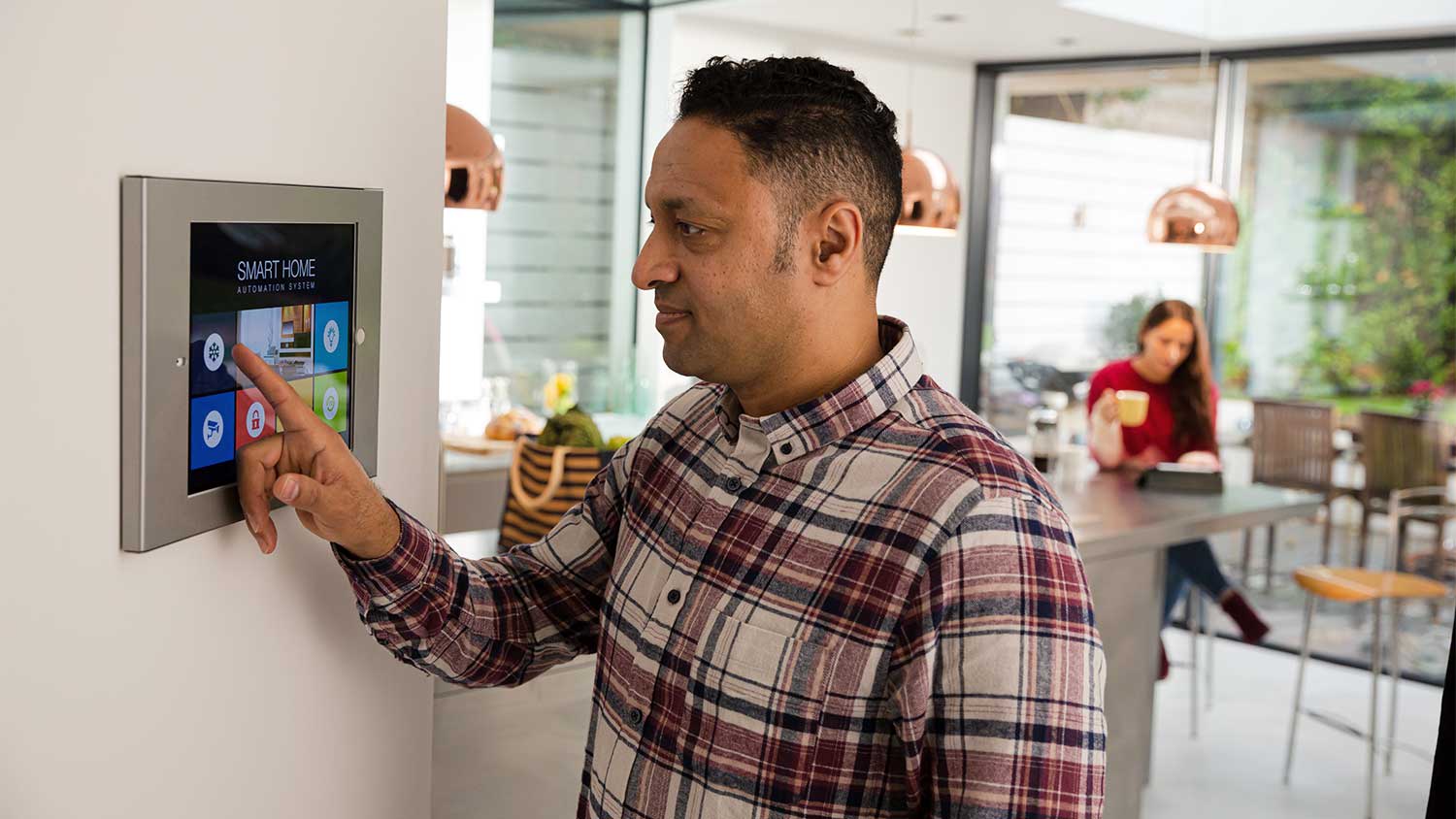 Man setting digital thermostat to turn ac on