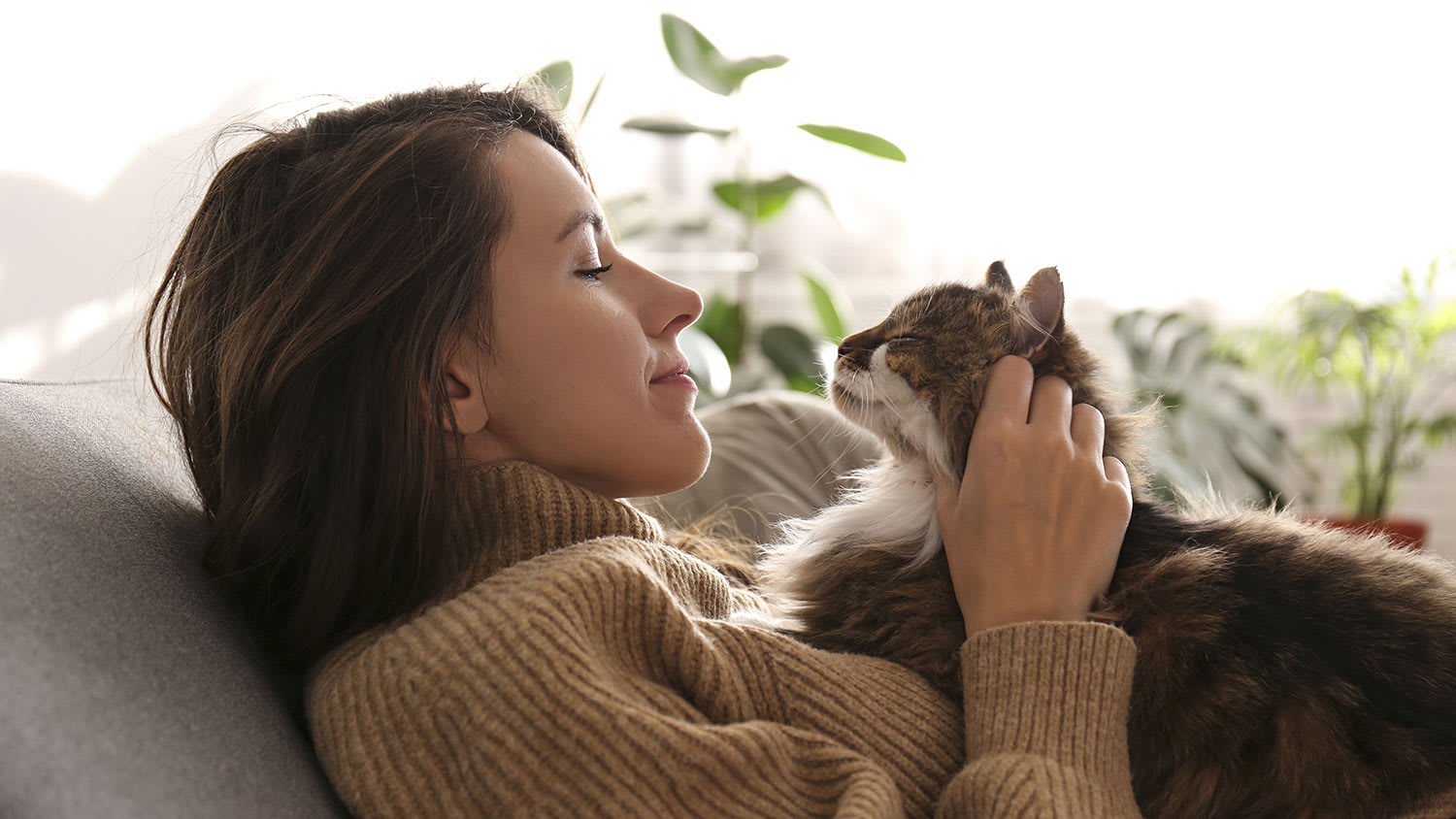Woman sitting on a couch holding her cat