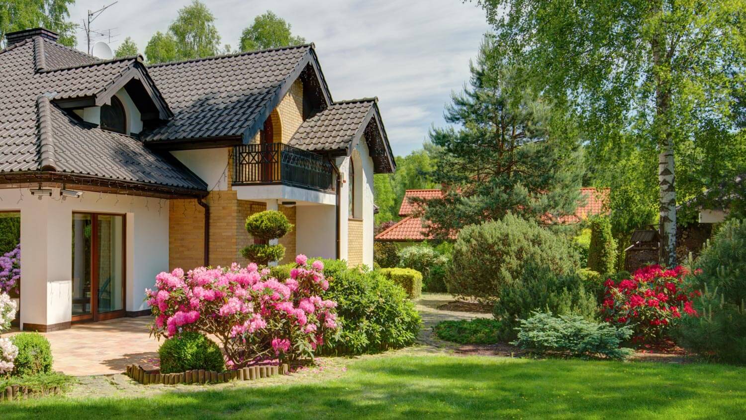 The exterior of a house with a big tree in the garden