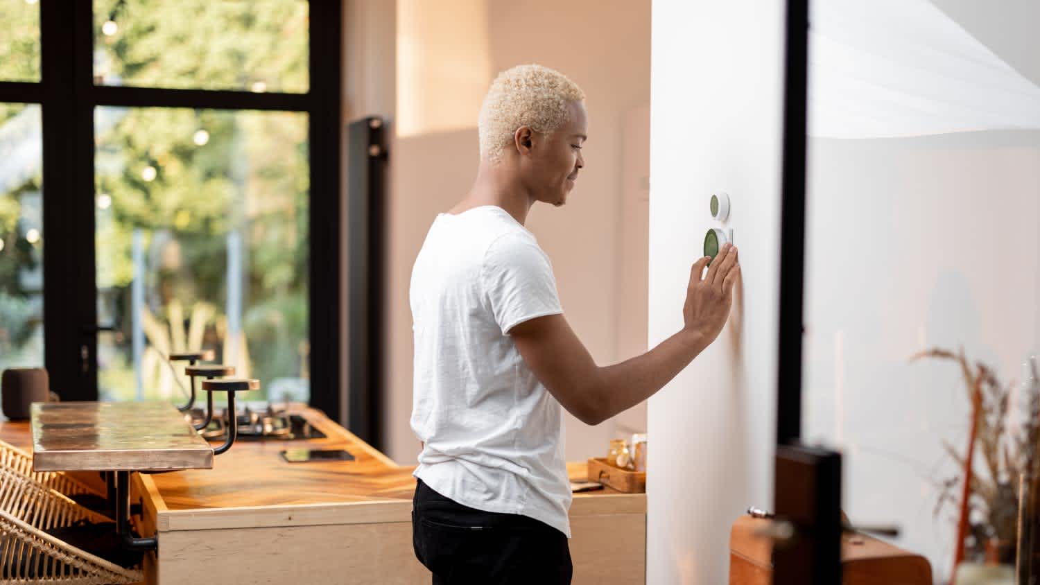 Man choosing temperature on thermostat