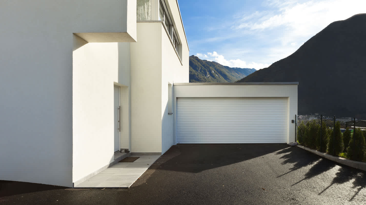 A single door white garage next to the house