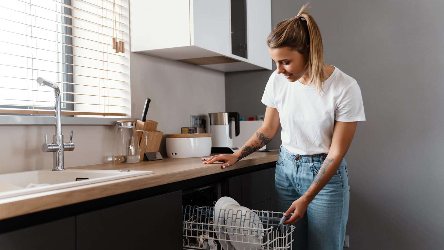A woman loading the dishwasher