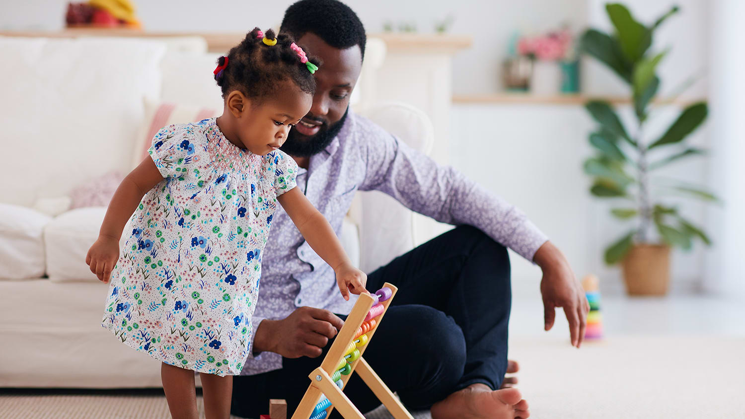 Father plays with his little girl on the carpeted floor