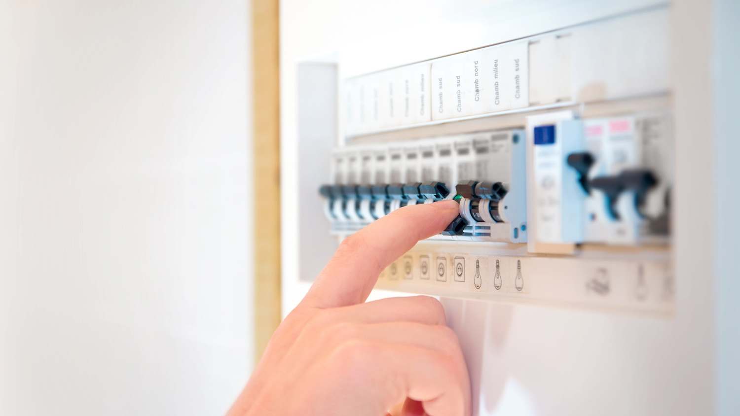 Close-up of a hand turning off a circuit breaker