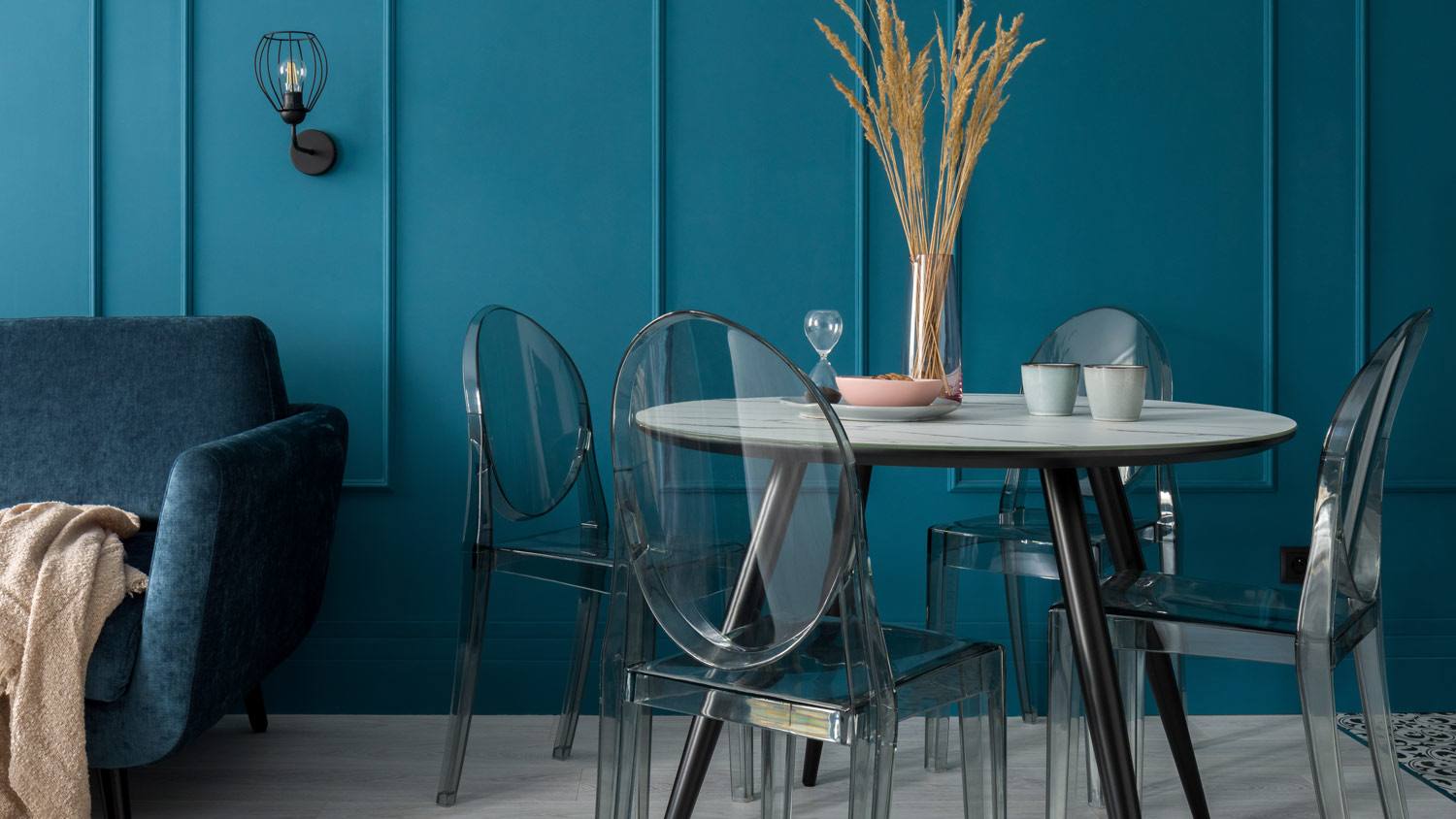 A dining room with a deep blue wall in the background