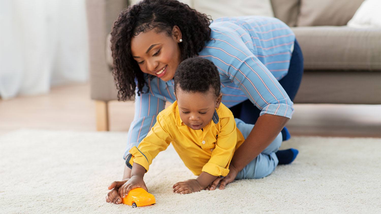 Mother and toddler son playing on the carpet