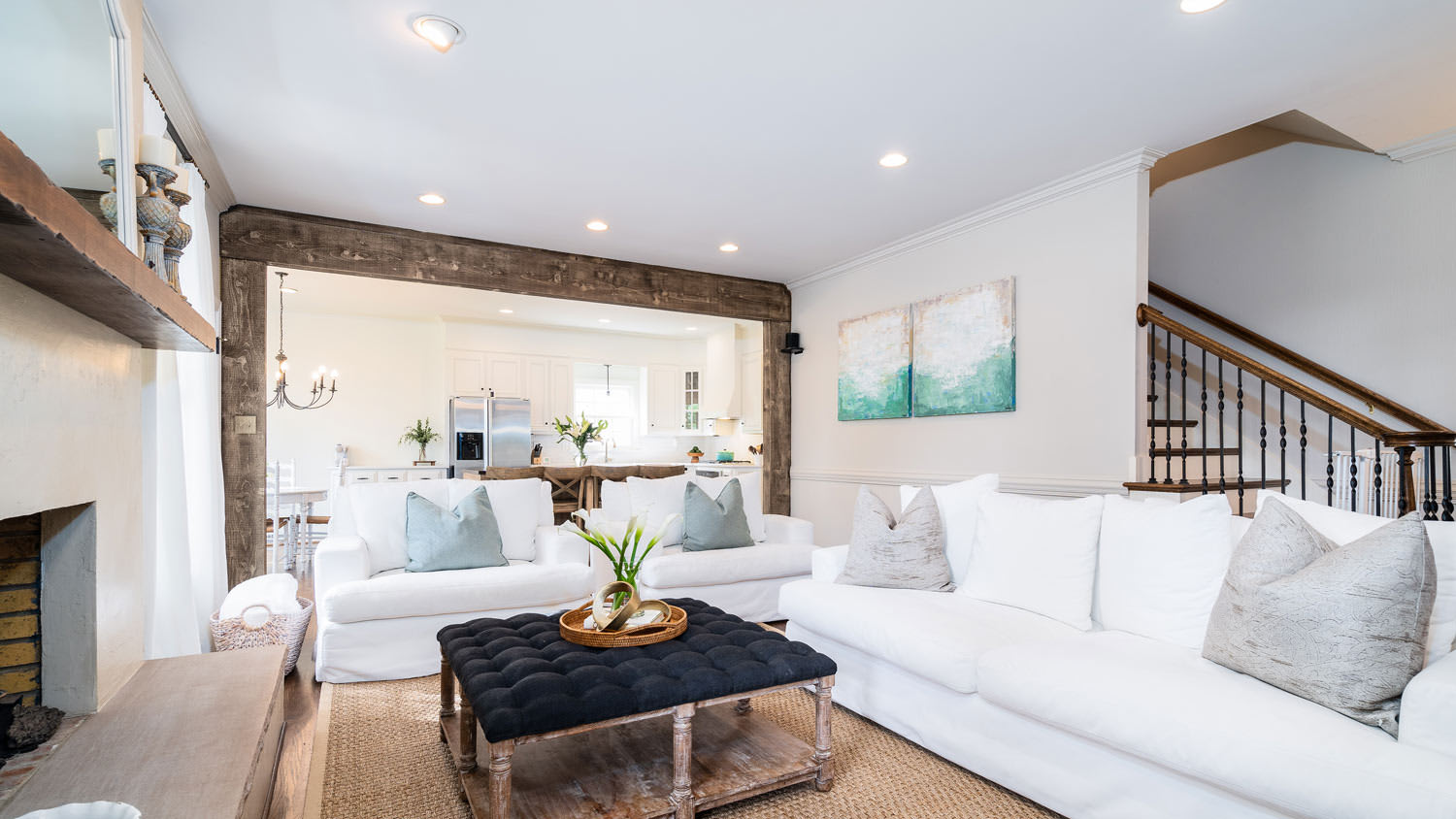 A living room with a white cozy sofa and recessed lighting on the ceiling
