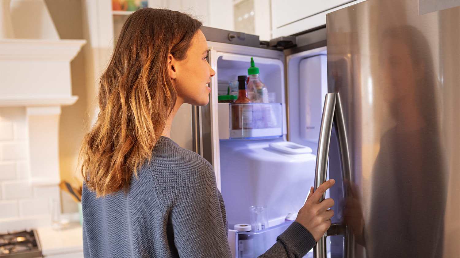 woman standing in front of open fridge