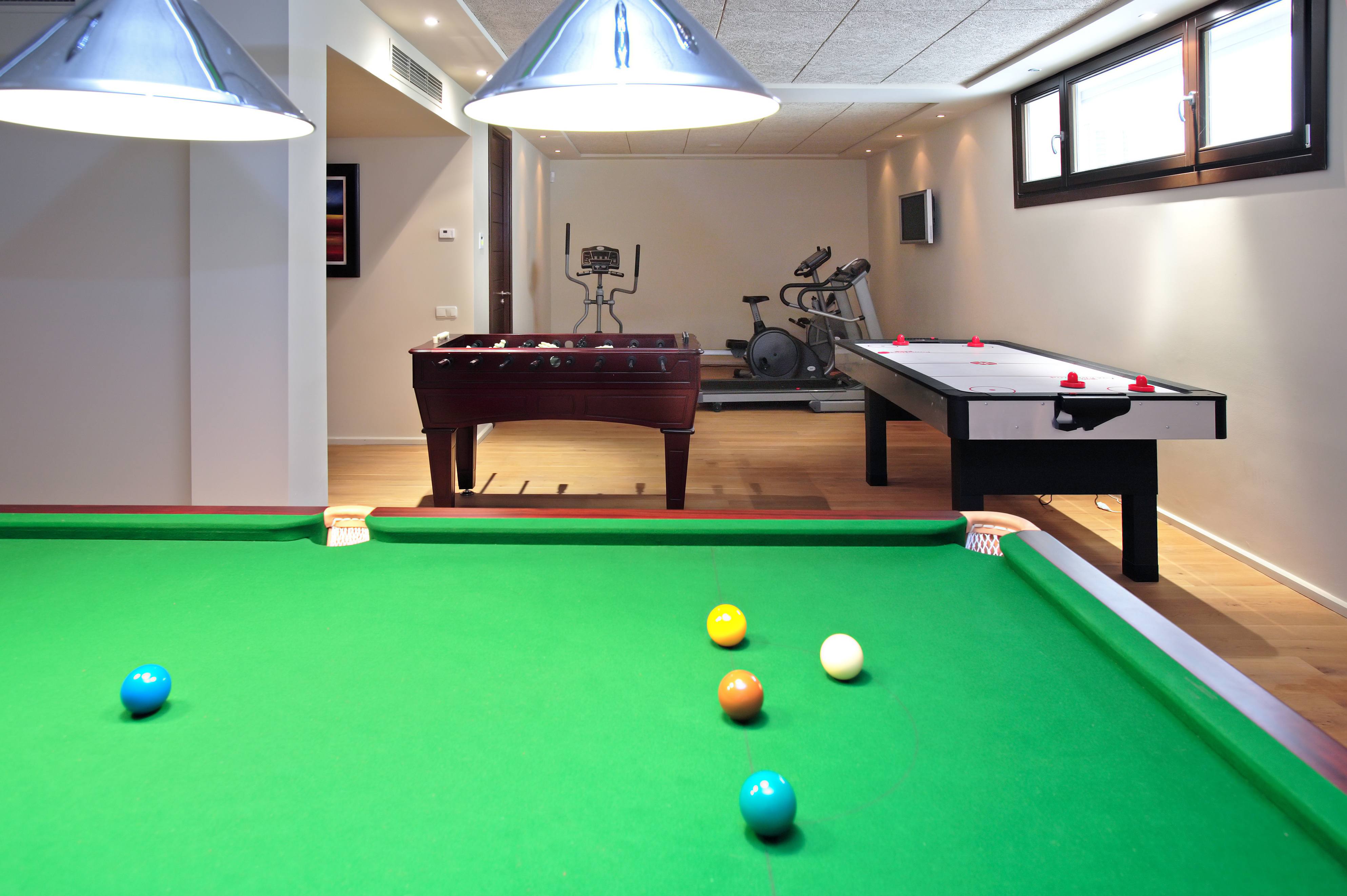 Basement home gym that has workout equipment and a pool table