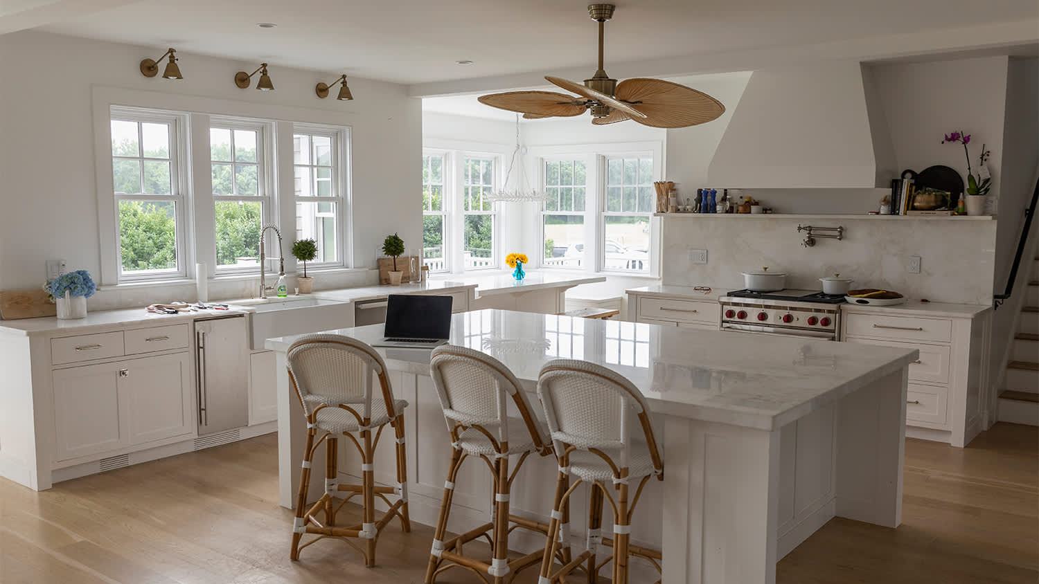 large white kitchen with ceiling fan above island