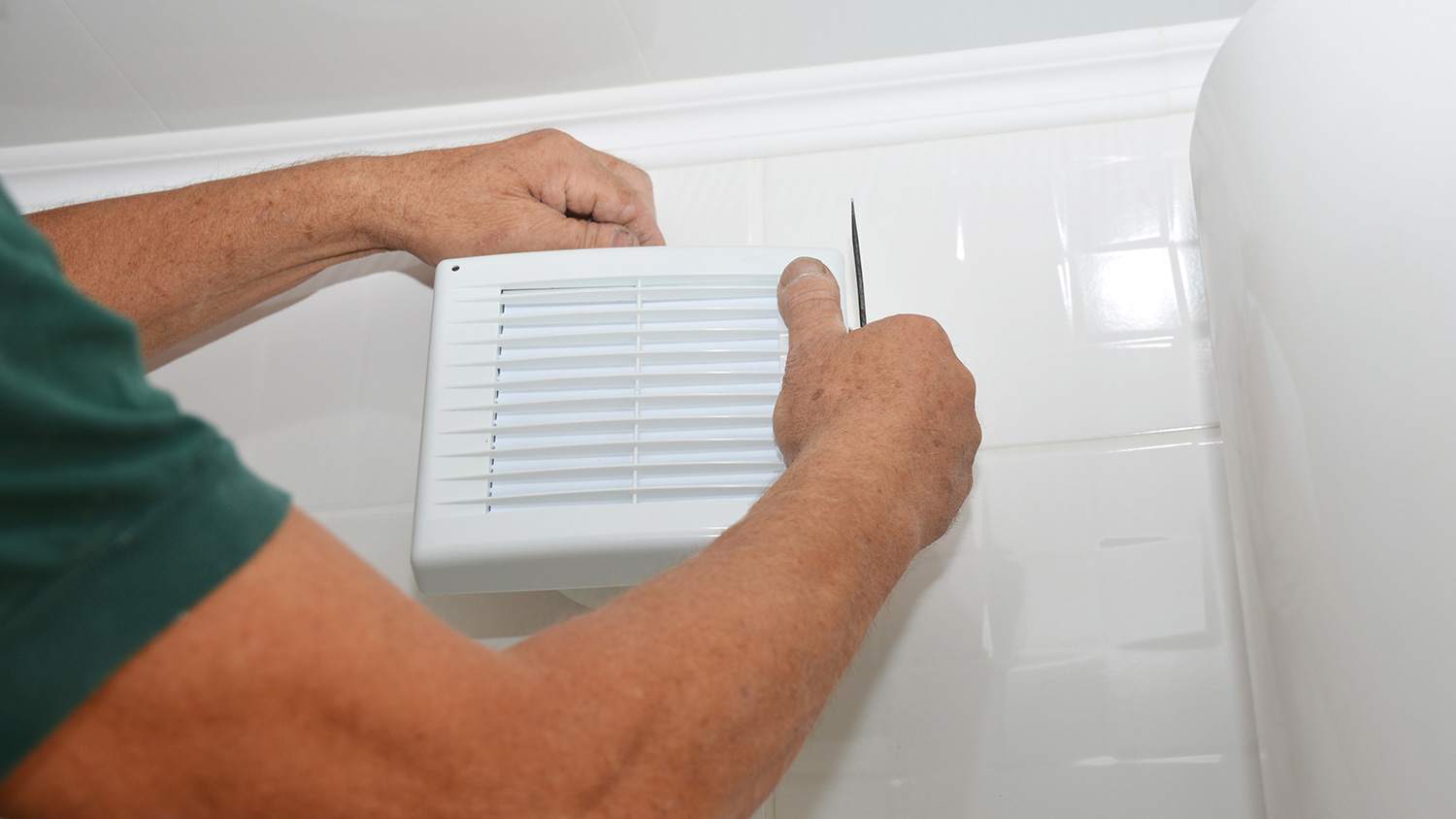Handyman installing bathroom fan cover