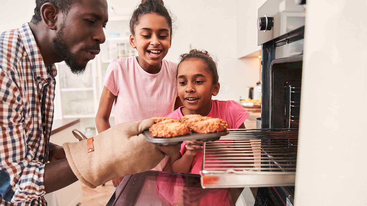 father and daughters baking in the kitchen