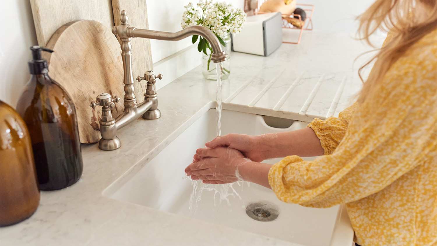 Woman washing hands at the kitchen sink