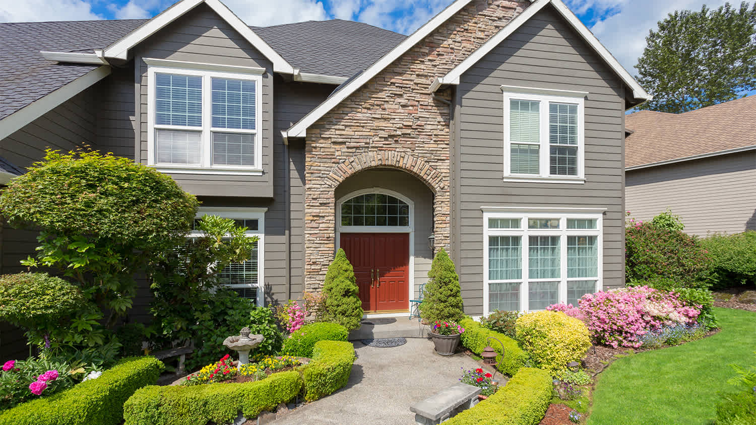 home with lush front yard with bushes and shrubs